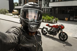 Motociclista che si fa un selfie con il casco